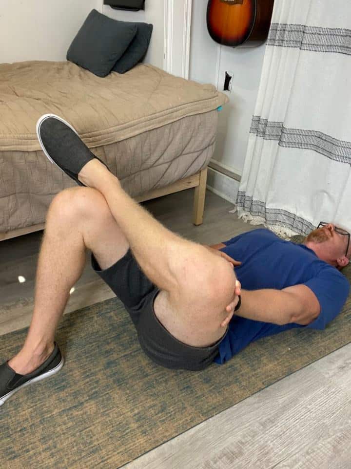 Coach Todd demonstrating the Figure 4 Hip External Rotation Stretch step 2 as part of the exercises for Gluteal Tendinopathy, aimed at increasing hip flexibility and reducing muscle tension
