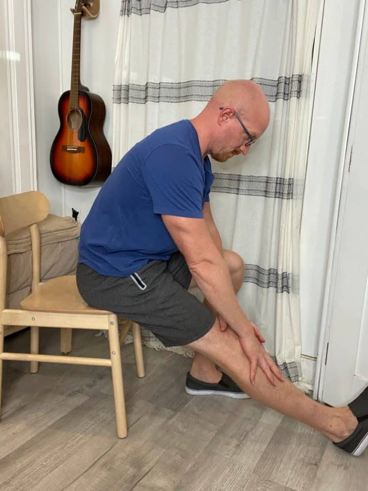 Coach Todd demonstrating seated hamstring stretch to increase leg muscle flexibility and alleviate lower body tension