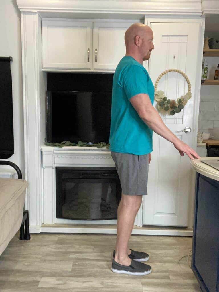 Coach Todd showcasing Standing Hip Extension, an exercise aimed at improving hip strength and mobility, supportive for those managing Patella Chondromalacia