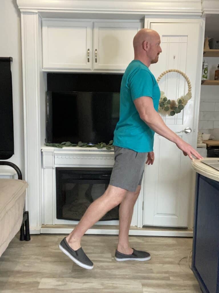 Coach Todd executing Standing Hip Extension step 2, an integral component of the exercise routine to counteract hip tendinopathy, promoting hip strength and flexibility