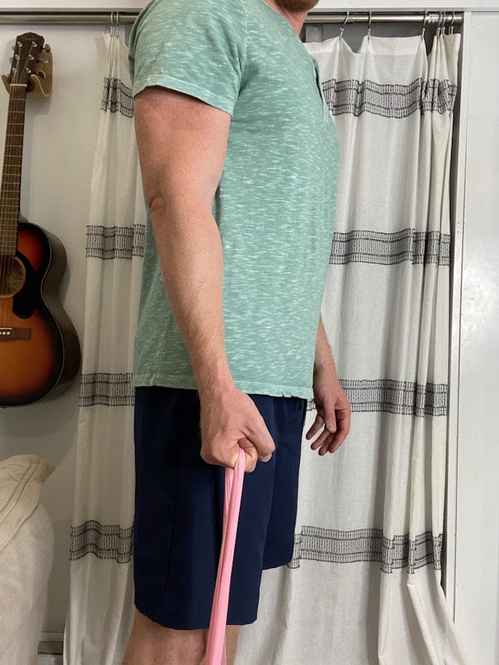 Demonstration of wrist flexion with a resistance band, a fundamental exercise for strengthening the muscles surrounding the elbow joint and ligaments.
