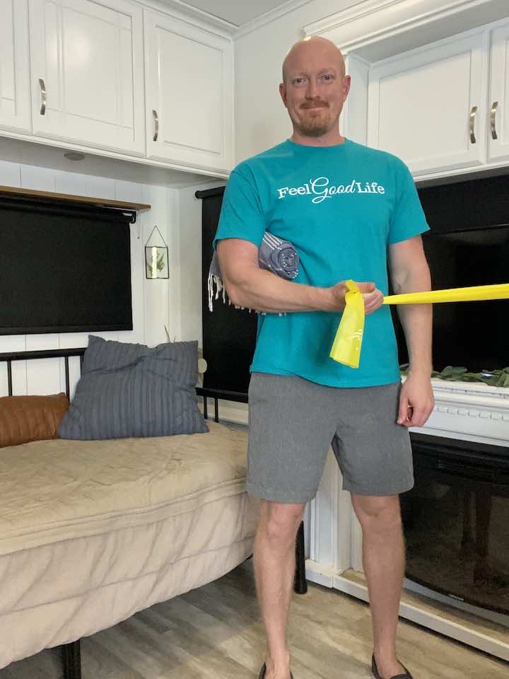 Coach Todd expertly demonstrates external shoulder rotation using a resistance band, a recommended exercise for subacromial impingement syndrome relief.