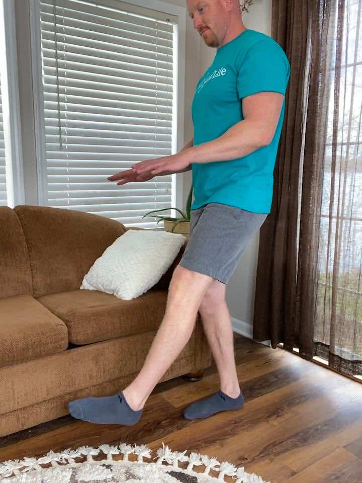 Coach Todd demonstrating a single leg balance progression exercise as a part of an exercises for arthritis, aimed at enhancing balance, strengthening lower body muscles, and promoting joint stability