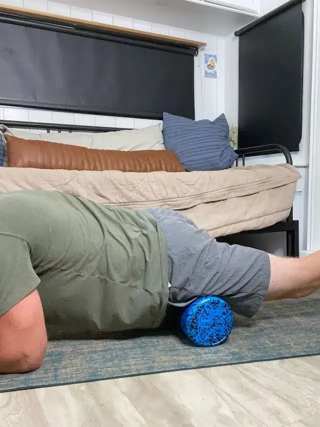 Coach Todd using a foam roller to target and alleviate tension in the hip flexors, directly influencing psoas pain reduction.
