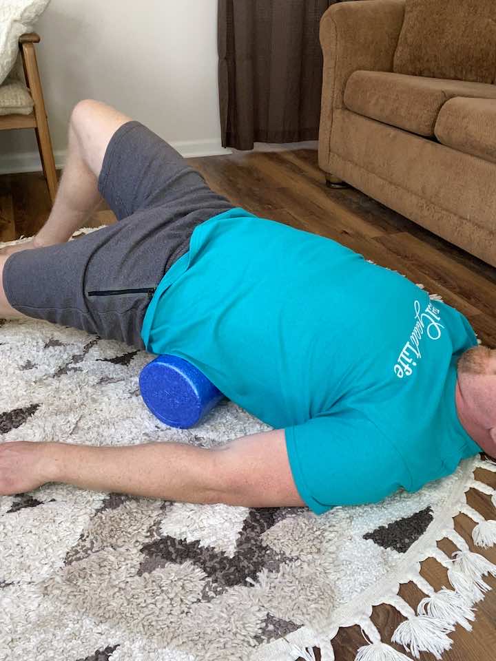 Utilizing foam roller to gently massage and stretch the lower back area.